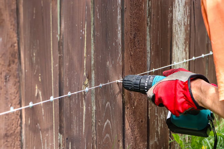 Carpenter repairing wooden fence