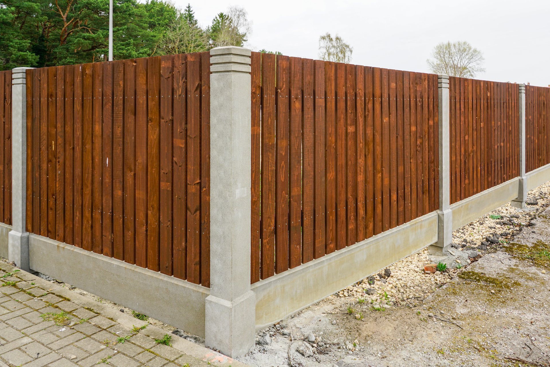 New fence with factory-made concrete posts and wooden plank spans